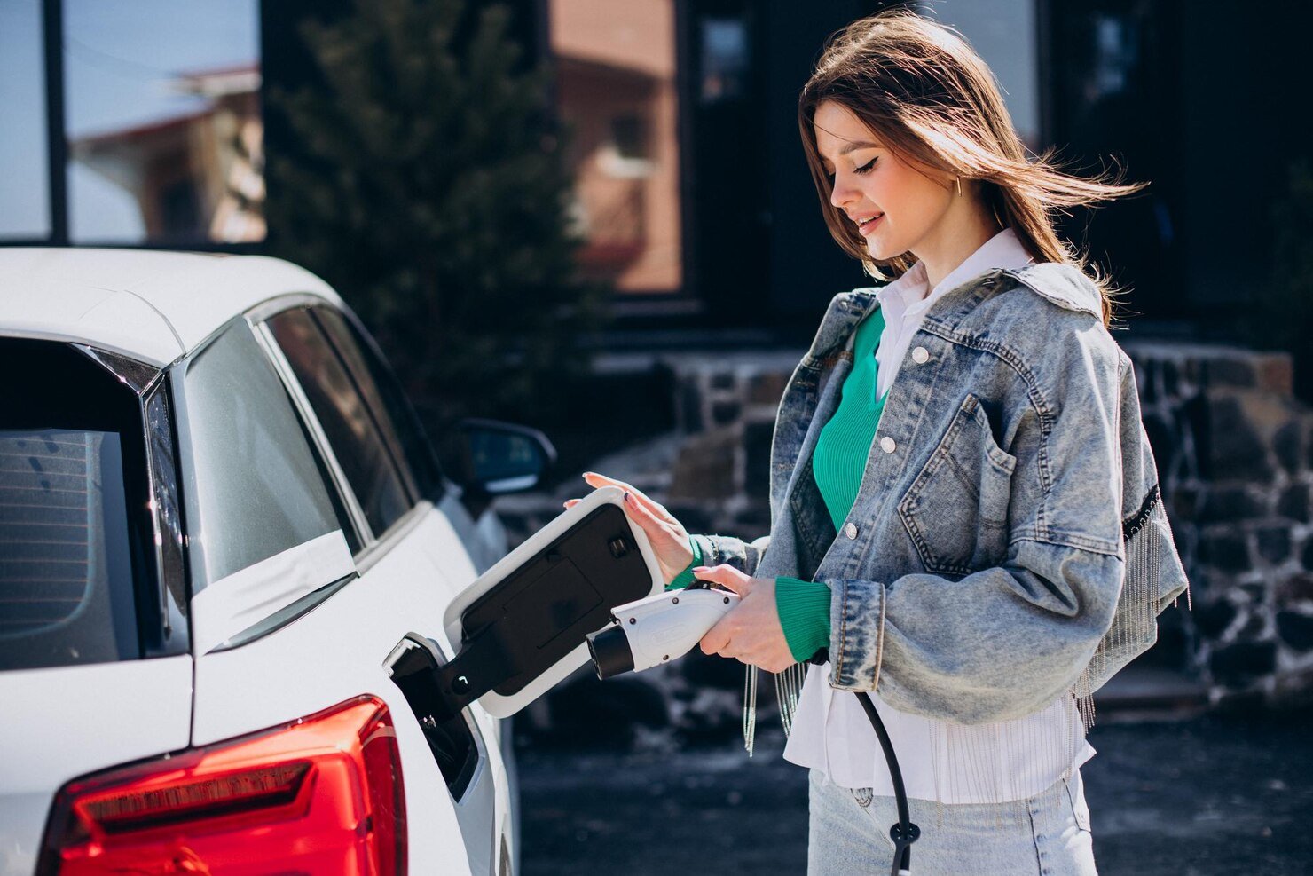 woman-charging-her-electric-car-with-charging-pistol_1303-31603